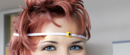 Trageweise des ALDs mittels Stirnband mittige an der Stirn.  