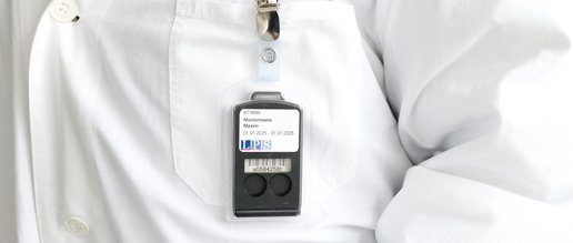 Tragebeispiel für eines Albedos an der äußeren Brusttasche des Laborkittels.