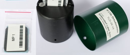 Umgebungsdosimeter Bestandteile - links Detektorkarte und Schutzhülle, rechts offenere Halter mit eingestecktem Detektor.